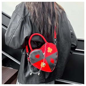 Detail of heart-shaped crossbody bag with poker suits pattern and silver metal chain