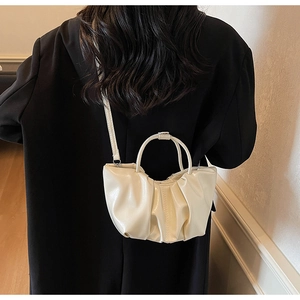 Chic beige pleated cloud bag shown with model in stylish black blazer for office aesthetic