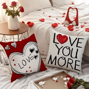 Pair of decorative linen Valentine pillow covers featuring Love You More heart designs