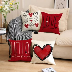 Detail of four Valentine's linen pillowcases with red heart prints on a beige sofa