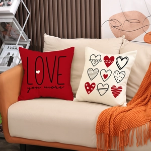 Detail of red and beige Love You More linen pillow covers set on a cozy sofa