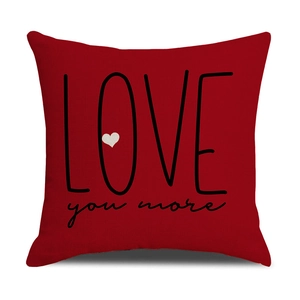 Close-up of red linen pillow cover with Love You More text and heart print texture