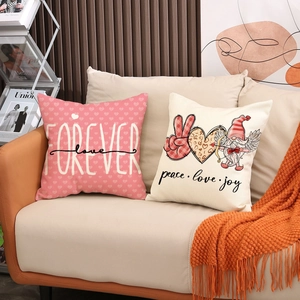 Detail of Valentine cushion covers with gnome and heart prints on a beige sofa