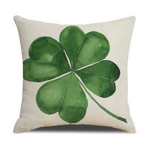 Close-up of four-leaf clover pillow with watercolor print on textured linen fabric