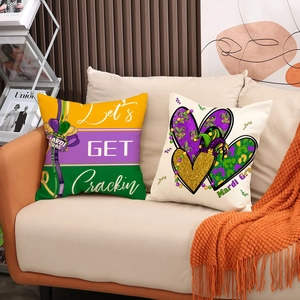 Set of two Mardi Gras pillow covers with festive lettering on a warm cozy sofa