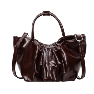 Deep brown pleated bucket bag in glossy PU leather with top handles and shoulder strap
