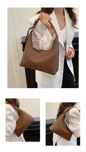 Détail du sac demi-lune en cuir marron avec foulard géométrique et logo embossé élégant