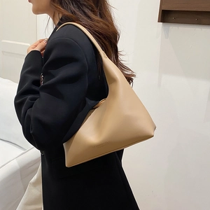 Chic beige hobo bag with minimalist geometric design shown from a side-angle view