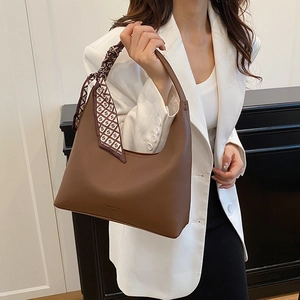 Brown leather hobo shoulder bag with stylish silk scarf and minimalist curved handle