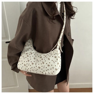 Détail du sac hobo en velours côtelé avec imprimés nœuds et texture vintage d'automne