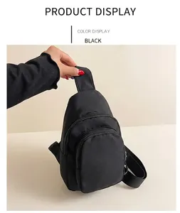 Détail du sac bandoulière en nylon noir avec double fermeture éclair et sangle
