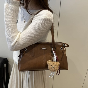 Retro brown leather tote bag with fashion tag and cute bear pendant for daily style