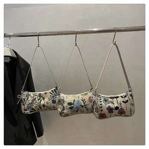 Detailed view of vintage floral fabric underarm bags with elegant pearl butterfly charms