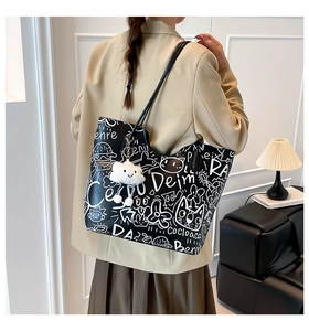 Detailed view of the street-style graffiti pattern and white plush cloud charm on a tote bag
