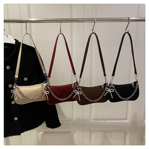Detail of four matte underarm bags with elegant chain straps and crystal bows