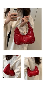Detail of red patent leather crescent bag featuring chunky silver chain and rivet accents