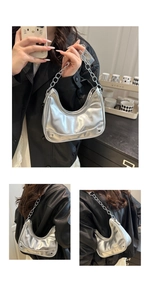 Detailed macro of silver metallic hobo bag with punk rivets and chunky chain strap