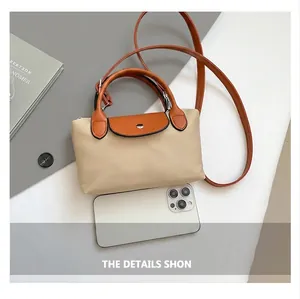 Petit sac bandoulière en nylon montré à côté d'un smartphone pour illustrer sa taille