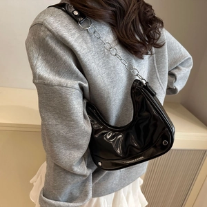 Minimalist black patent leather underarm bag with silver chain strap and rivet details