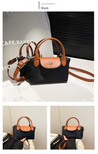 Détail du sac en nylon noir avec poignées en cuir marron et bandoulière réglable