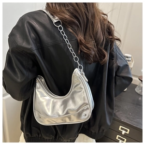 Close-up of metallic silver crescent bag featuring chic texture and chain leather strap