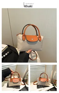 Détail du sac à main en nylon kaki avec poignées en cuir orange et fermeture magnétique