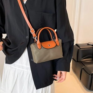 Sac dumpling en nylon vert olive avec bandoulière en cuir orange-brun sur modèle