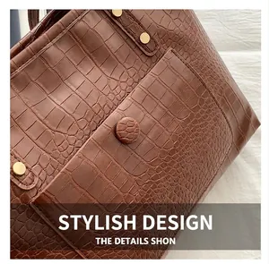 Close-up of the vintage brown crocodile texture and gold hardware on the tote bag
