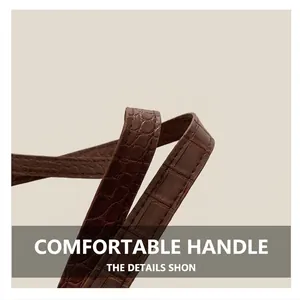 Detail of dark brown crocodile embossed leather strap on a minimalist vintage tote bag