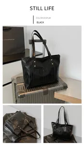Detail of black crocodile texture tote bag with golden rivets on a luggage suitcase