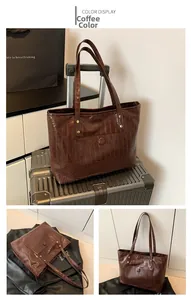 Detail view of coffee-colored tote bag featuring crocodile embossed texture and front pocket