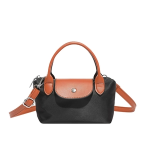 Mini sac à main en nylon avec rabat en cuir et bandoulière sur fond blanc uni