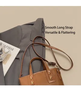 Detail shot of vintage brown leather bucket bag with gold studs and adjustable shoulder strap