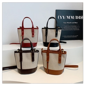 Detailed view of four canvas bucket bags with leather trim in assorted vintage colors