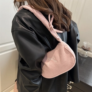 Sac bandoulière en velours côtelé rose avec broderie nœud porté par le mannequin
