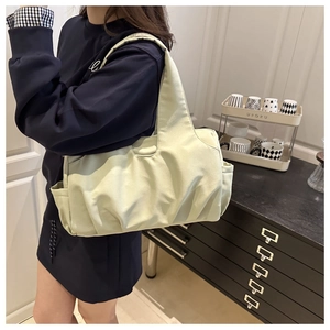 Dettaglio di una grande borsa tote plissettata verde pistacchio in nylon con tasche laterali