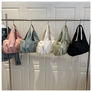 Row of waterproof nylon tote bags in pink, grey, cream, green and black colors