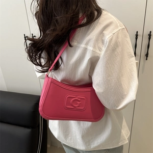 Chic pink leather underarm baguette bag with embossed G logo for women in minimalist style