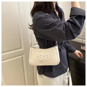 Detail of off-white faux leather underarm bag featuring a textured G embossed pattern