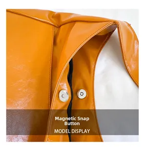Detailed macro view of the silver magnetic snap closure on high-gloss orange leather bag