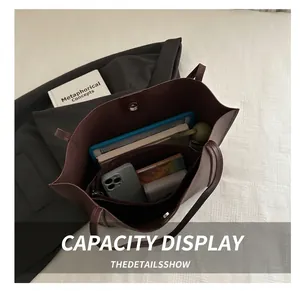 Detail view of burgundy tote bag showing spacious interior with zipper compartment
