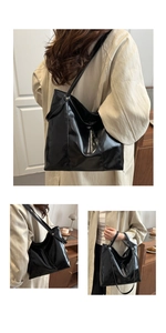 Détail d'un grand sac cabas noir brillant avec de longues anses et texture cuir