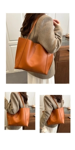 Detail of a large brown tote bag showing the textured PU material in a minimalist office style