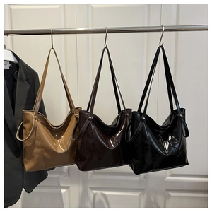 Close-up of glossy faux leather tote bags in khaki, dark coffee, and sleek black colors