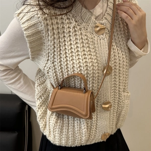 Brown hourglass leather mini bag with curved base and crossbody strap on a model