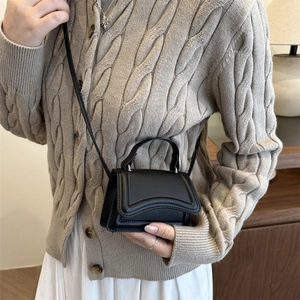 Chic black hourglass handbag with curved flap and leather strap for women