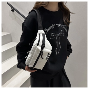 Detailed view of white nylon chest bag featuring a black brand label and multi-zipper pockets