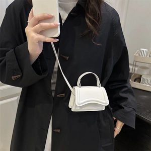Minimalist white leather mini crossbody bag with wave-curve flap and top handle for women