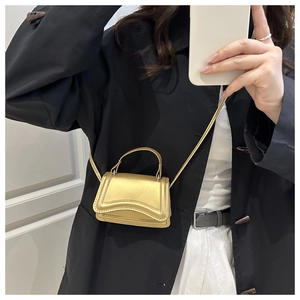 Selfie allo specchio mostra mini borsa dorata a clessidra con finitura metallica
