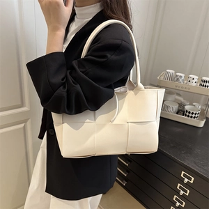 White woven tote bag with oversized grid pattern and shoulder straps for daily use
